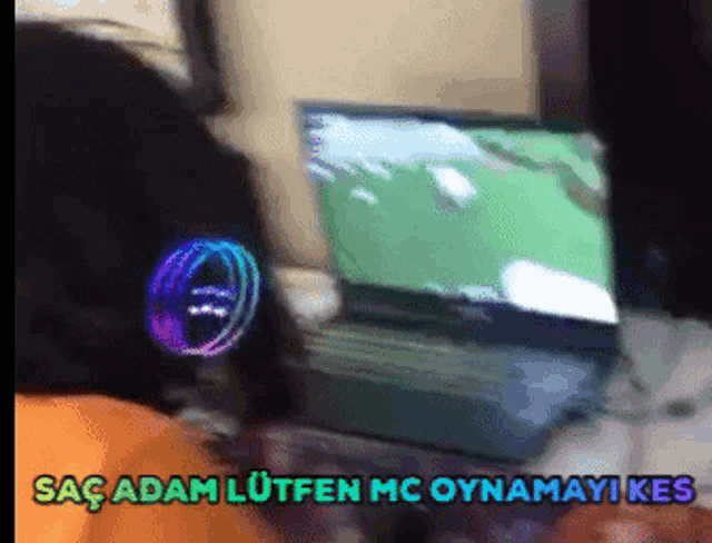 a person wearing headphones is playing a video game on a laptop computer