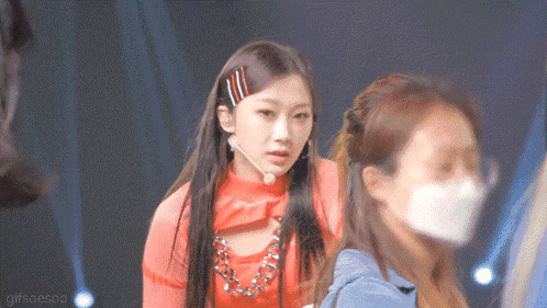 a woman wearing a face mask is standing next to another woman on a stage .