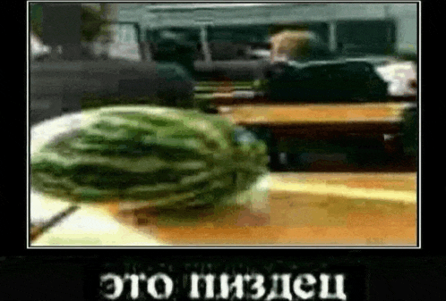 a watermelon is sitting on a table in front of a classroom