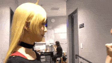 a woman in a yellow wig is standing in a hallway with a sign that says emergency room 2