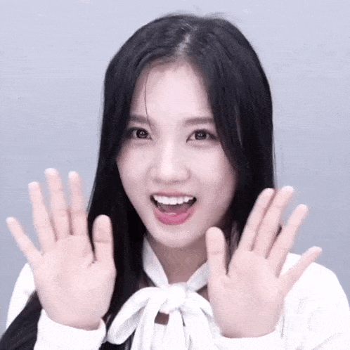 a woman with long black hair is making a funny face with her hands in the air