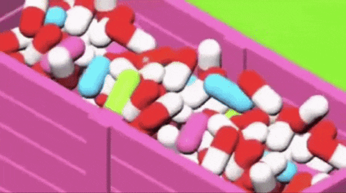 a pink box filled with lots of colorful pills .