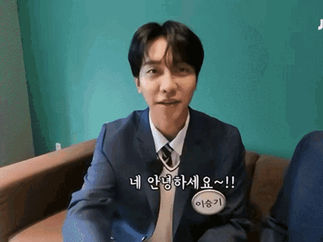 a man in a suit and tie sitting on a couch
