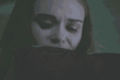 a close up of a woman 's face with a black tape around her mouth .