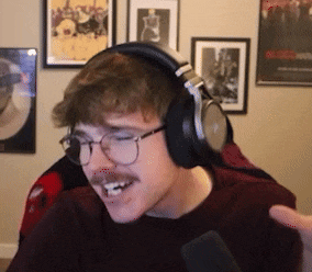 a man wearing headphones and glasses is smiling and holding a microphone