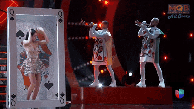 a woman in a dress is dancing in front of a queen of spades card