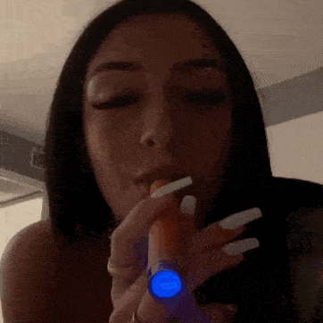 a woman is smoking a cigarette in a dark room .