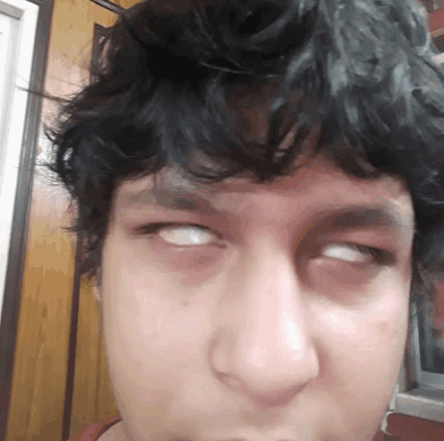 a close up of a person making a funny face with their eyes closed