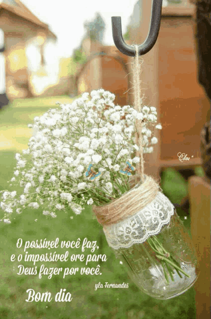 a bouquet of baby 's breath hangs from a hook with the words bom dia below it
