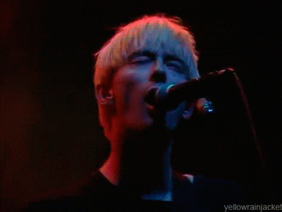 a close up of a person singing into a microphone with the words yellowrainjacket below