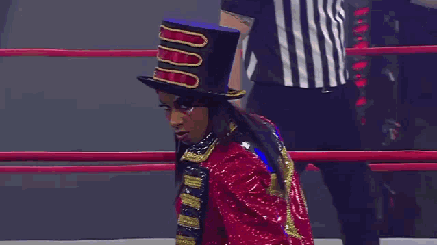 a man in a top hat is standing in a boxing ring