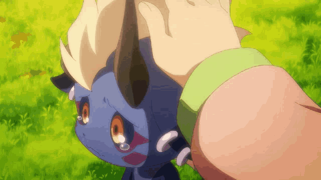 a person is petting a small blue monster in a field