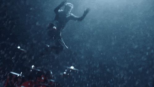 a man is flying through the air in front of a drum set in the dark