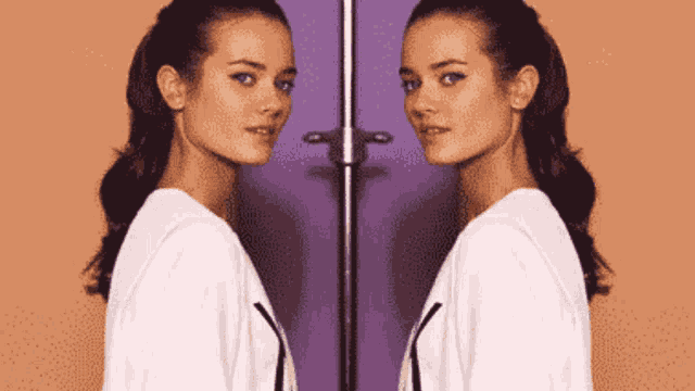 a woman is standing in front of a mirror with her reflection