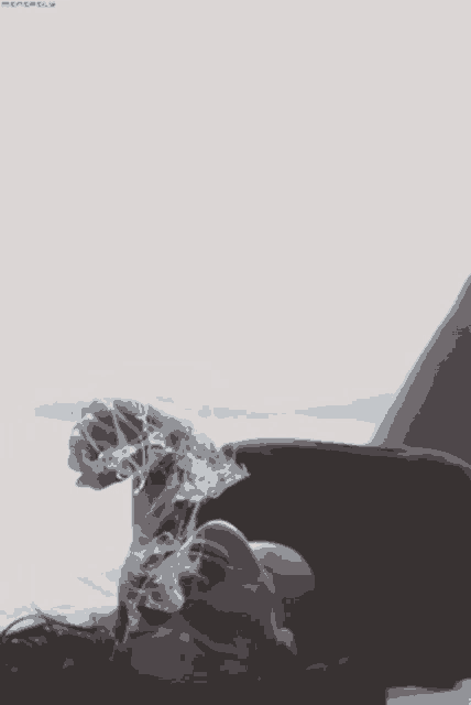 a woman laying on a bed smoking a cigarette with the word minerals on the bottom left