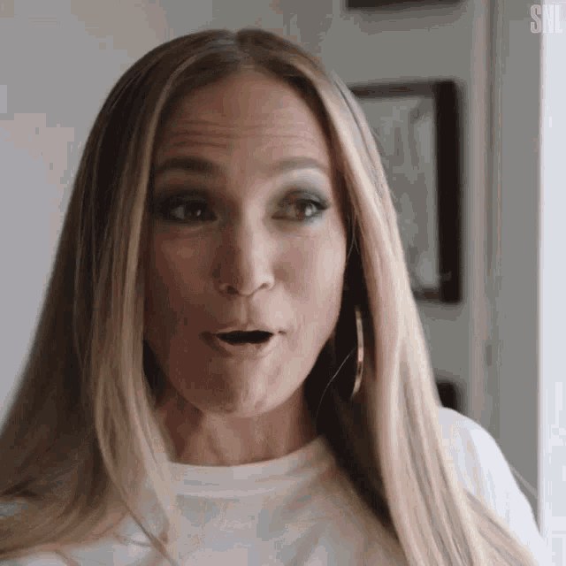 a close up of a woman 's face with her mouth open and a surprised look on her face .