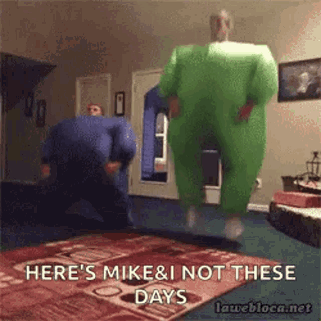 a man in a green inflatable suit is jumping in the air .
