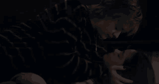 a man in a striped sweater is laying on top of a woman