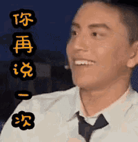 a man in a white shirt and tie is smiling with chinese writing behind him