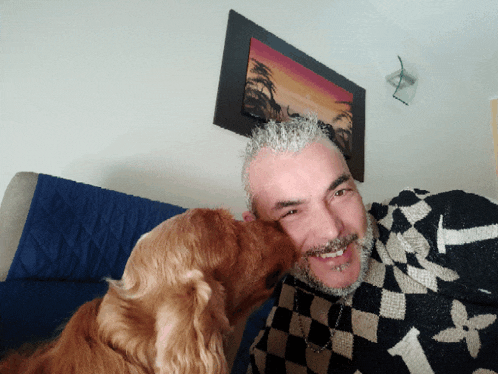 a man with a beard is being kissed by a brown dog