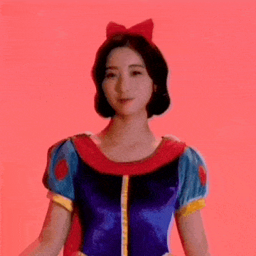 a woman in a snow white costume with a red bow on her head .