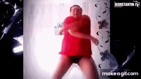 a man in a red shirt and black shorts is dancing .