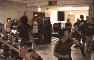 a group of people are dancing in a room with a man playing a guitar