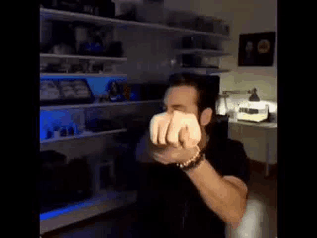 a man is making a funny face in a room with a lot of shelves .