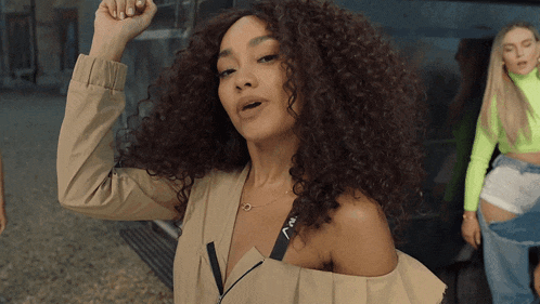 a woman with curly hair is wearing a jacket that says nv