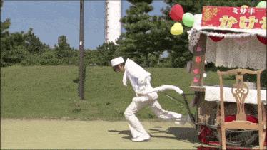 a man is pulling a cart with balloons and a sign that says ' a ' on it
