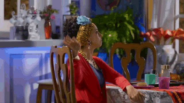 a woman in a red sweater is sitting at a table