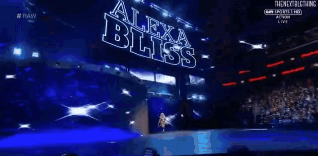 a woman in a bliss shirt is walking down a stage