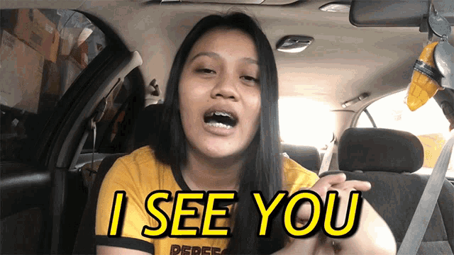 a woman sitting in a car with the words i see you above her