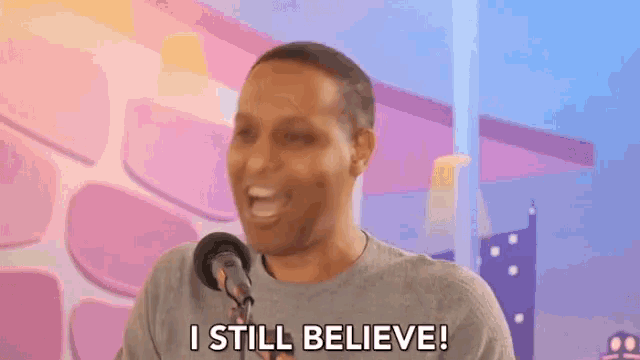 a man is speaking into a microphone and says i still believe