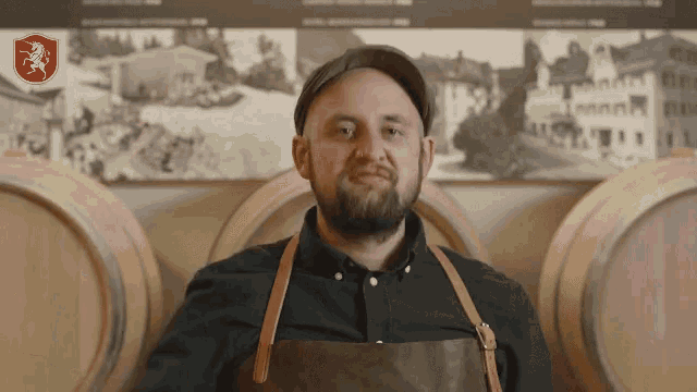 a man with a beard wearing an apron and a hat