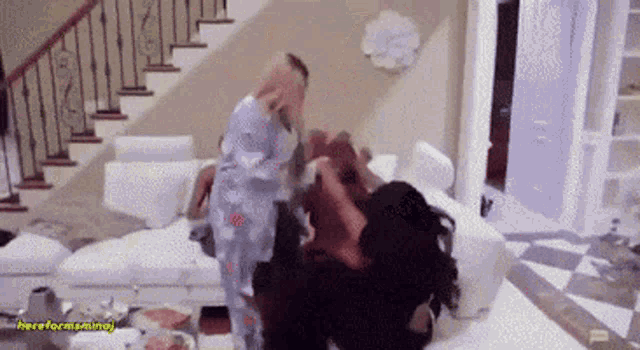 a group of women are having a fight in a living room