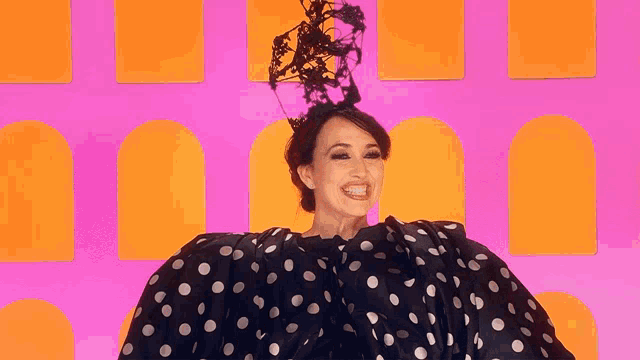 a woman wearing a polka dot dress and a black hat says ciao