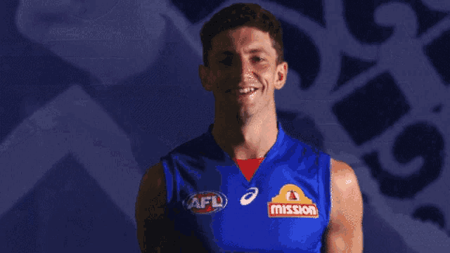 a man wearing a blue tank top that says mission
