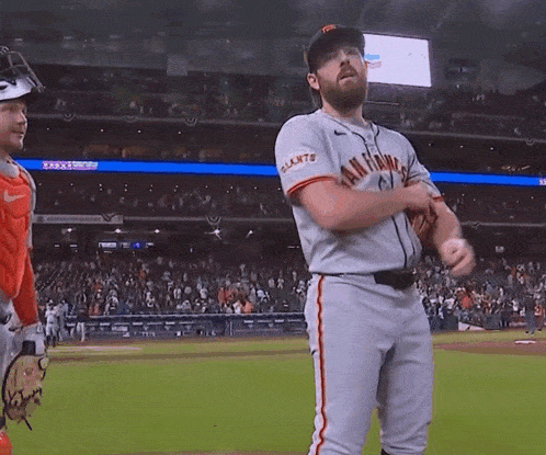a man in a san francisco giants jersey stands on the field