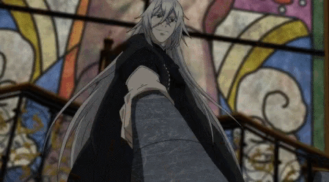 a man with long grey hair is standing in front of a stained glass window .