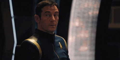 a man in a star trek uniform is looking at something