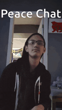 a man with glasses is standing in front of a mirror with the words peace chat on it
