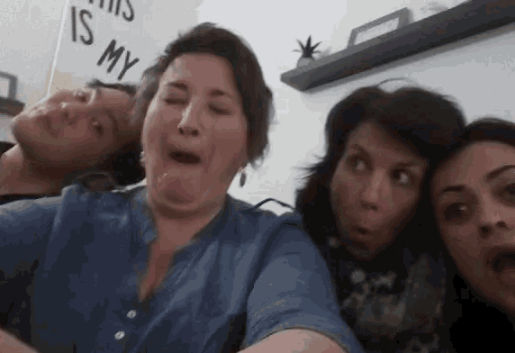 a group of people are making funny faces while taking a selfie together .
