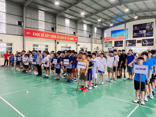 a group of young boys are standing on a court with a sign that says club yen my