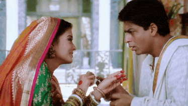 a man is putting something on a woman 's hand