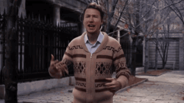 a man wearing a sweater that has a greek key pattern on it
