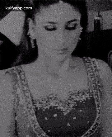a black and white photo of a woman in a red dress looking down .