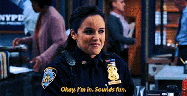 a woman in a police uniform is smiling and says okay i 'm in sounds fun