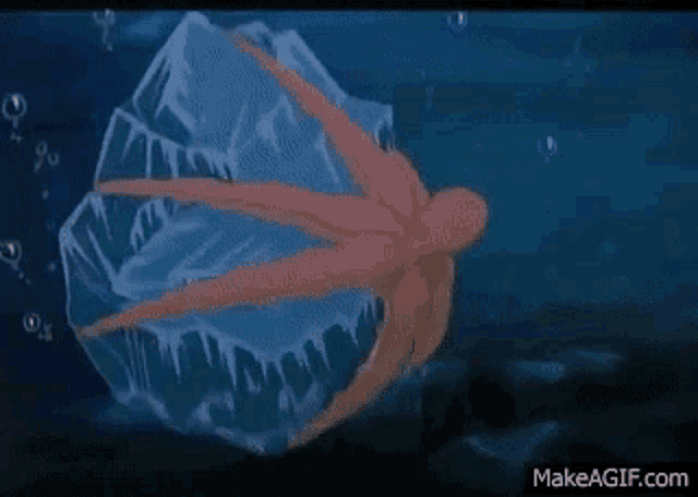 an octopus is swimming in the ocean next to a large ice cube .