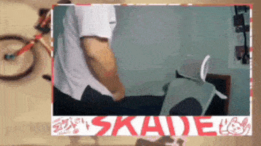 a man is sitting in front of a bicycle and a sign that says skade